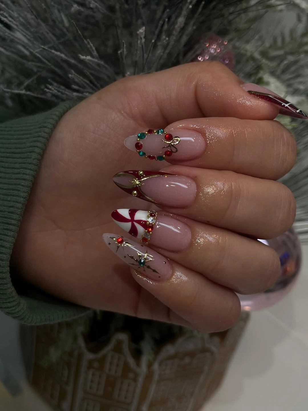 Long pink nails with red ribbons, gold details and a red-and-green wreath motif.