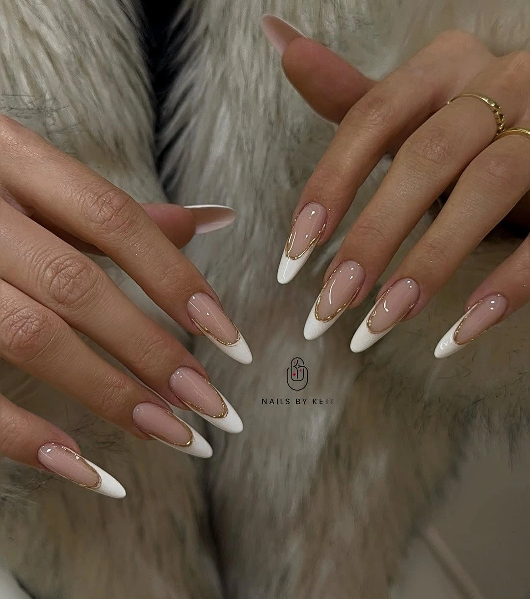 Long almond nails with white French tips and fine gold curved outlines.
